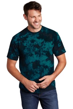 A man wearing a blue and black tie-dye t-shirt, smiling and standing against a plain background.