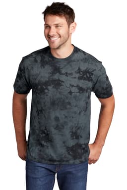 A man models a Port & Company Crystal Tie-Dye Tee in shades of grey and black, featuring a fluid tie-dye pattern.