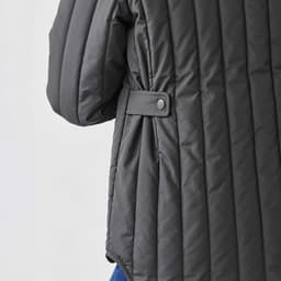 A thermal jacket in dark grey with quilted texture and button detail on the sleeve. It features a relaxed fit.