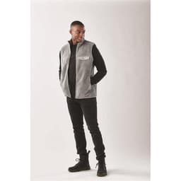 A men's grey Sherpa fleece vest with a front pocket, styled with a black long-sleeve shirt and trousers.