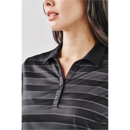 A close-up of a woman's black striped polo shirt with a collar and buttons, featuring a logo.