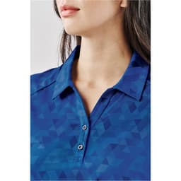 A close-up of a blue women's polo shirt featuring a geometric pattern and a classic collar with buttons.