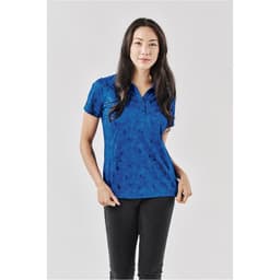 A woman models a women's polo shirt in shades of blue with a geometric pattern and a logo on the chest.