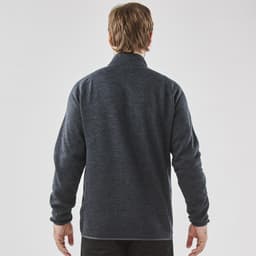 A men's full zip fleece jacket in dark grey, featuring a simple design and a collar. Branding is visible on the jacket.