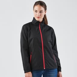 A woman wearing a black rain jacket with red zippers and accents, featuring a collar and side pockets.