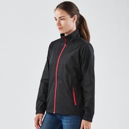 A black rain jacket with a red zip, featuring a high collar and side pockets, displayed on a model.