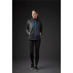 A woman wearing a black rain jacket with blue accents, featuring a zip front and a pocket.