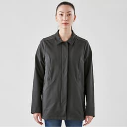 A woman wears a dark grey, long-sleeved Soho jacket with a collar and pockets, featuring a logo.