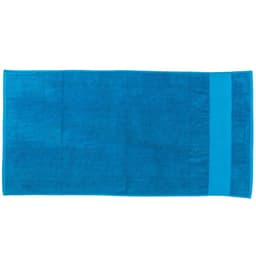 A large, rectangular beach towel in vibrant blue, featuring a solid colour design and a branding logo.