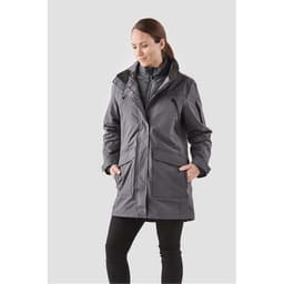 A woman wearing a grey 5-in-1 system jacket with pockets and a zip front, featuring a logo.