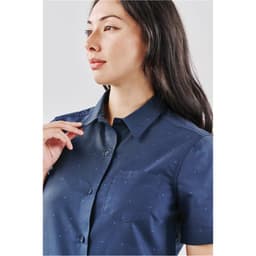 A blue button-up women's shirt with short sleeves and a small pocket, featuring a subtle pattern.