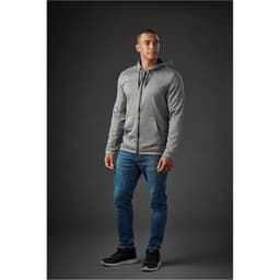 A grey zip-up hoody with a hood, paired with blue jeans, worn by a model against a dark background.