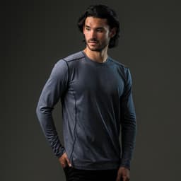 A man models a long-sleeve, navy blue T-shirt featuring a logo. The shirt has a slim fit and subtle detailing.