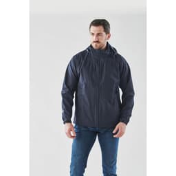 A man is wearing a navy lightweight rain jacket, featuring a hood and a logo on the chest.