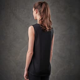 A woman wearing a black sleeveless tank top, viewed from the back, against a textured grey background.