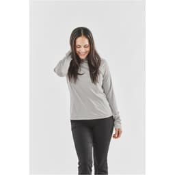 A woman wearing a long-sleeve, light grey women's t-shirt, featuring a round neck and fitted sleeves.