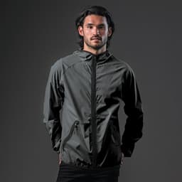 A man wearing a dark grey hooded rain jacket with a zip and a logo on the chest.