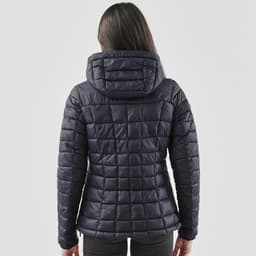 A women's puffer jacket in navy blue with a quilted design and a hood, viewed from the back.