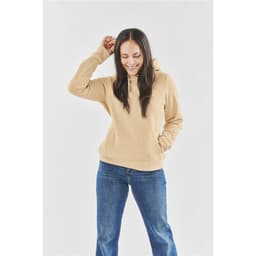 A women's fleece pullover hoody in a tan colour, paired with blue jeans, featuring a hood and front pocket.
