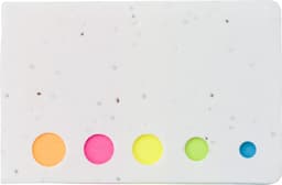 A white sticky note pad featuring colourful circular cutouts in pink, yellow, green, and blue, with speckles throughout.