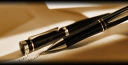 A sleek black Metal Charles Dickens® ballpen resting on paper, featuring a polished finish and a silver accent.