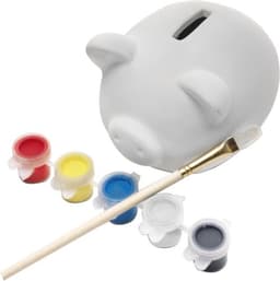 A white plaster piggy bank with a paintbrush and five pots of paint in red, yellow, blue, black, and white.