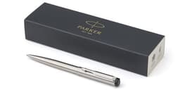 A stainless steel ballpen displayed alongside a dark box featuring a logo. The pen has a sleek, modern design.