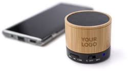 A bamboo wireless speaker in a circular design beside a smartphone, featuring a logo and control buttons.
