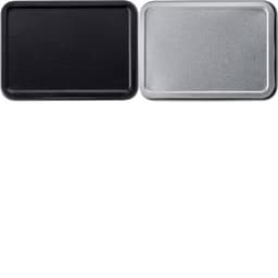 A metal tin with a black exterior and a silver interior, accompanied by a set of playing cards.