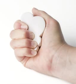A hand gripping a white foam cloud shape, showcasing its soft and squeezable texture.