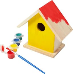 A wooden birdhouse kit featuring a yellow house with a red roof, paint pots, and a brush for decoration.