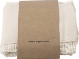 A set of three cream reusable cotton mesh produce bags, wrapped with a brown paper label.
