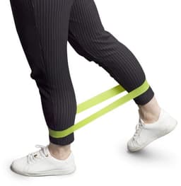 A set of three elastic sports bands in lime green, positioned around a person's calves while wearing black pinstriped pants and white shoes.