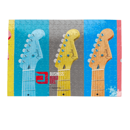 A large jigsaw puzzle featuring colourful guitar necks in blue, yellow, and grey, with a logo displayed on it.