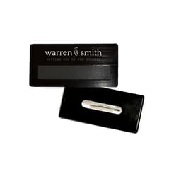 A black DIY staff badge with a magnet and a clip on the back. It features a logo.