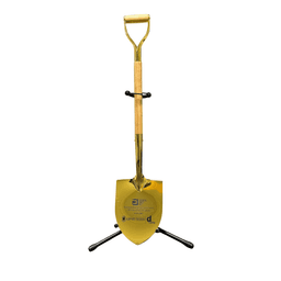 A shiny gold shovel with a wooden handle, displayed upright on a black stand. The stand has a logo.