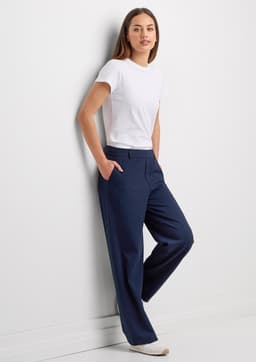 A pair of women's soft stretch pants in navy, worn by a model with a white t-shirt against a plain wall.
