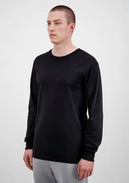 A black long sleeve men's t-shirt displayed on a model, featuring a simple design and fitted style.