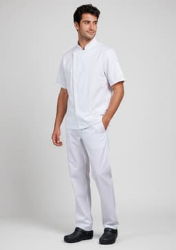 A white short sleeve chef jacket worn by a man, paired with white trousers and black shoes, featuring a logo.