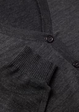A grey women's button front knit cardigan featuring a pocket and button detail. It includes a logo.