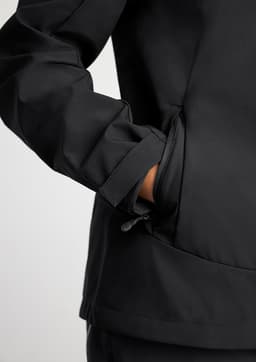 A black women's jacket with a close-up of the sleeve and pocket details, featuring a logo.