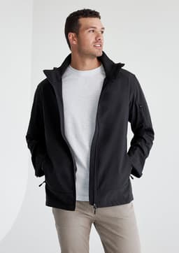 A man wearing a black rain jacket with a grey shirt underneath. The jacket has a logo on it.