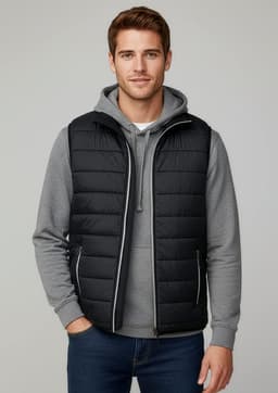 A black puffer vest worn over a grey hoodie, modelled by a man, featuring a zip front and a logo.