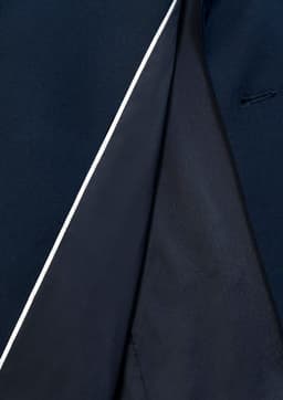 A navy blue jacket featuring a contrasting interior and a subtle white trim. It has a tailored fit.