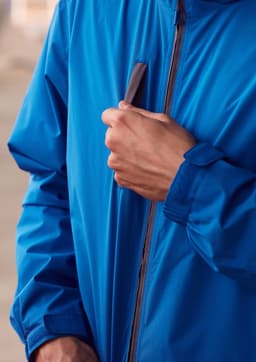 A blue unisex super light packable rain jacket with a zip and a logo on the chest.