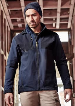 A man wears a navy blue unisex waterproof jacket with a hood. The jacket has a logo and is styled for casual wear.