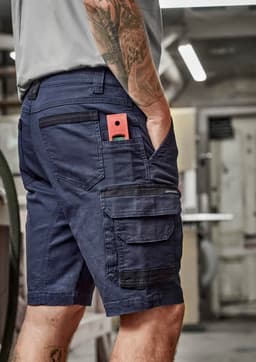 Men's streetwear shorts in navy with multiple pockets, featuring a logo and a rugged design suitable for workwear.