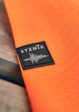 An orange unisex hoodie with a textured jacquard design and a branded logo.