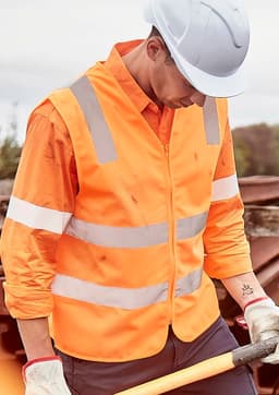 An orange unisex hi-vis vest with silver reflective strips, worn over a long-sleeve shirt, featuring a safety helmet.