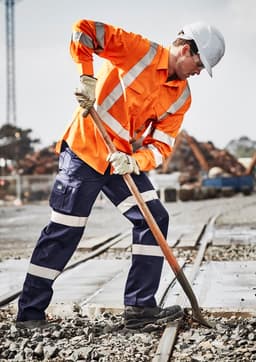 An orange long sleeve work shirt with reflective stripes, worn by a worker using a shovel in a construction environment.